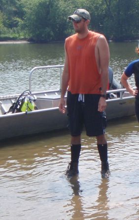 Josh Sherwood stands near a boat
